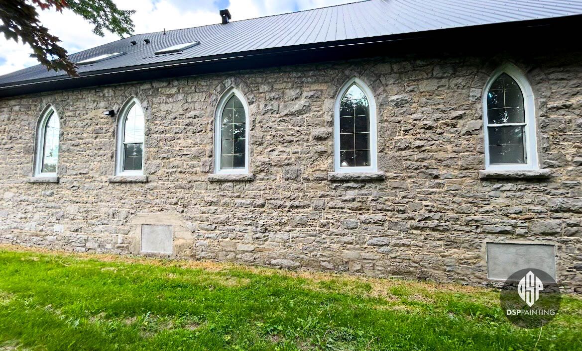 Side wall of the church before the frames were repainted, the five arched windows still white