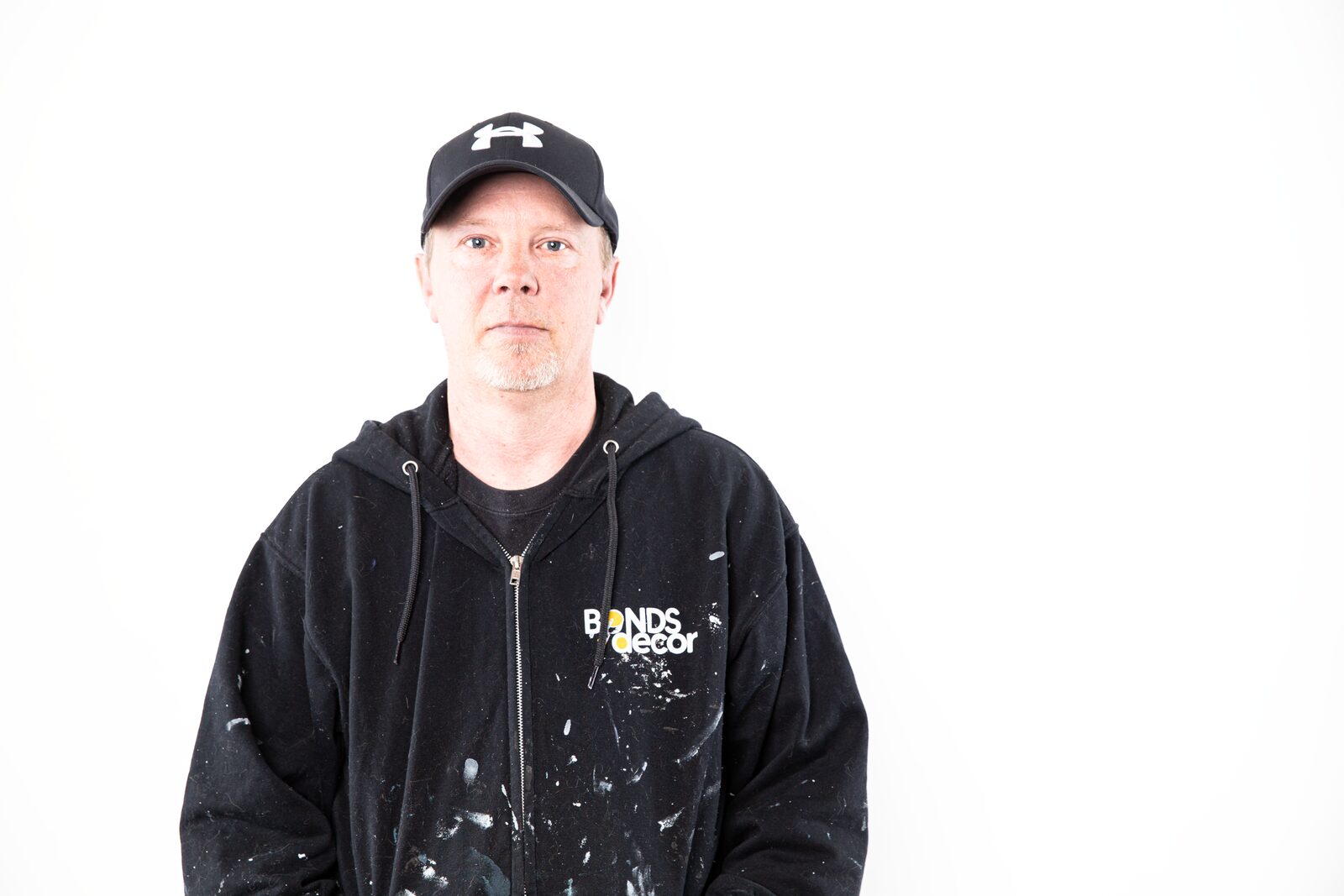 Derek Sparling, owner of DSP Painting, in a paint-spattered black work hoodie and cap